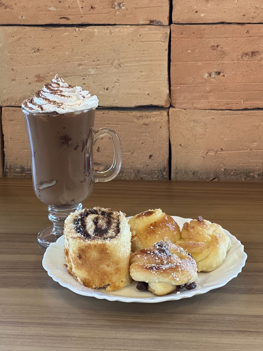 Chocolate quente Stravaganza com chantilly, servido com docinhos